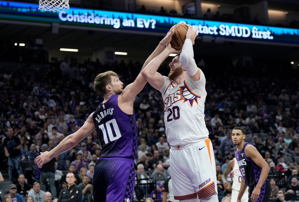 Jusuf Nurkic #20 of the Phoenix Suns is fouled by Domantas Sabonis #10 of the Sacramento Kings duri...