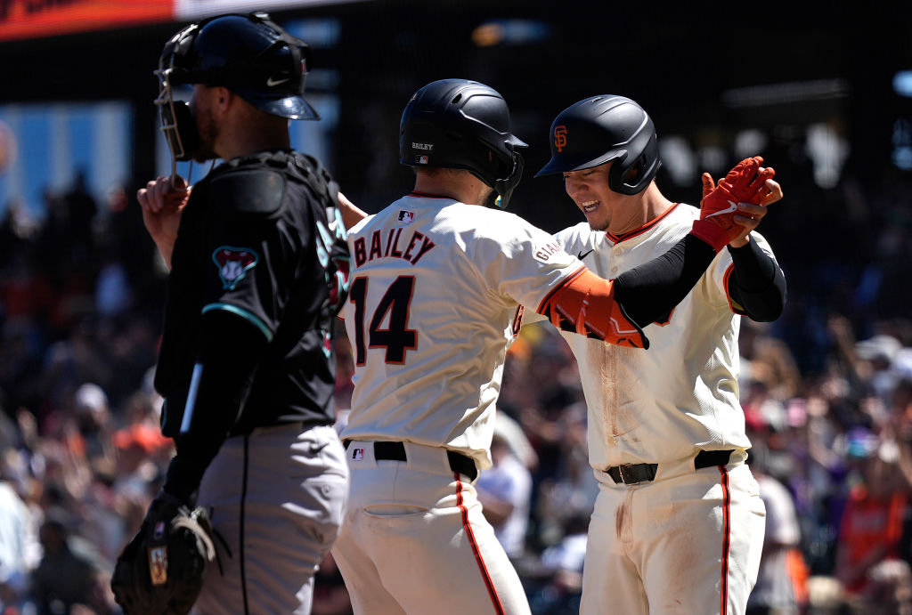 Patrick Bailey #14 and Wilmer Flores #41 of the San Francisco Giants celebrates after Bailey hit a ...