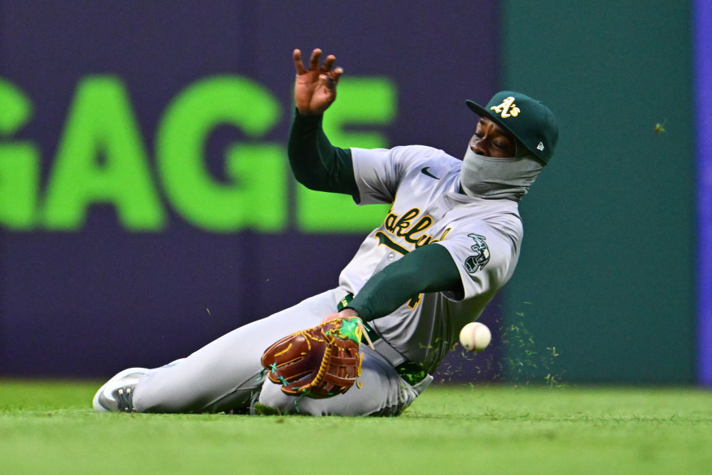 Right fielder Lawrence Butler #4 of the Oakland Athletics misses a fly ball hit by Steven Kwan #38 ...