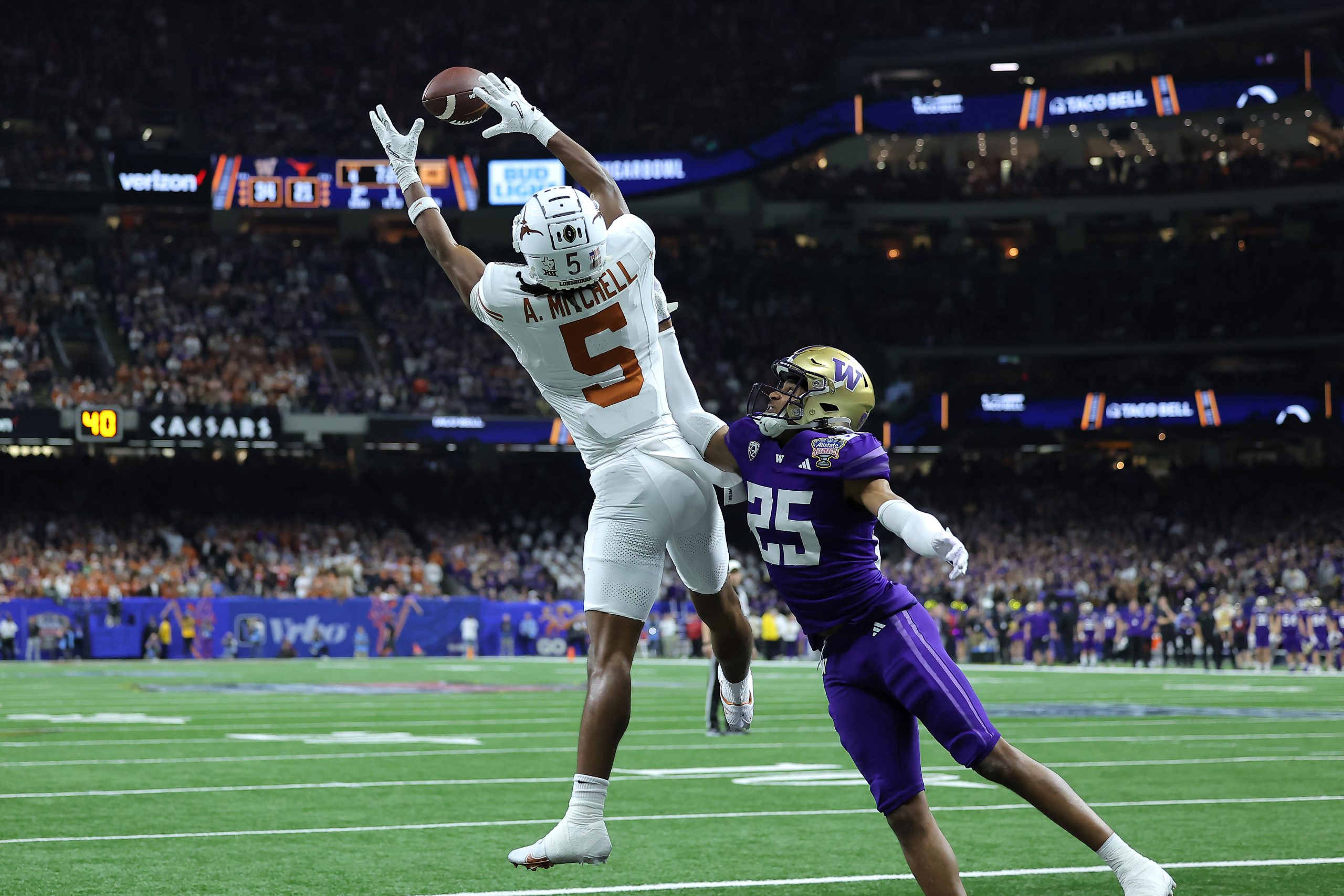 Adonai Mitchell #5 of the Texas Longhorns catches a touchdown pass against Elijah Jackson #25 of th...