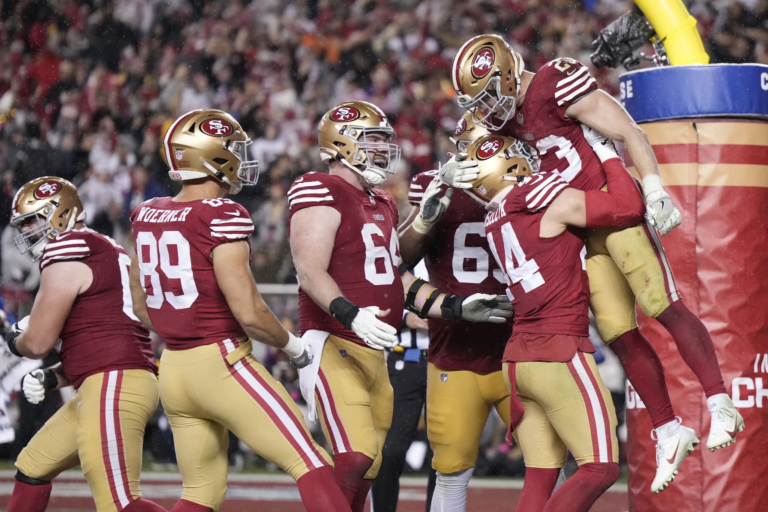 Christian McCaffrey #23 of the San Francisco 49ers celebrates with teammates after scoring a 6-yard...