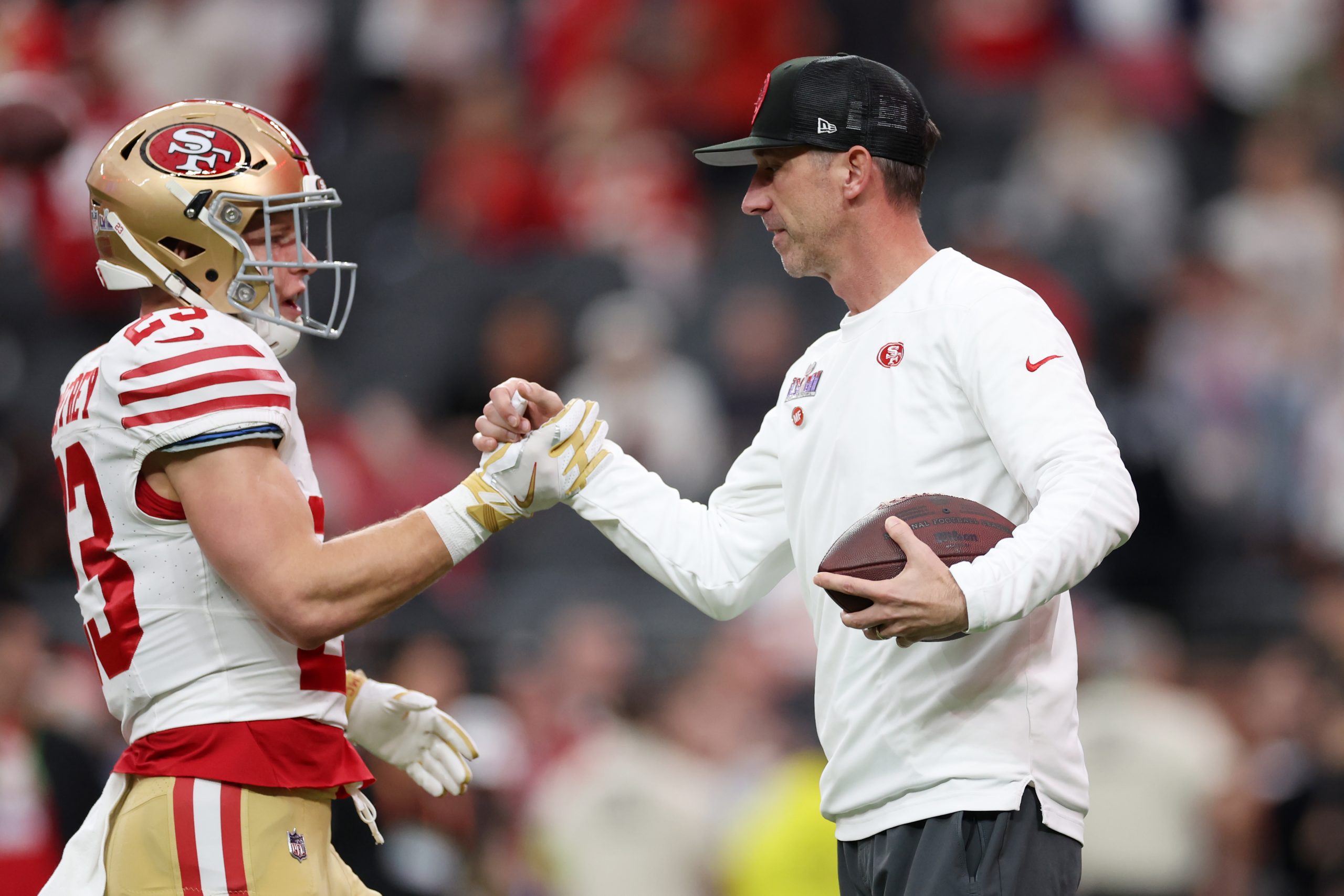 Head coach Kyle Shanahan of the San Francisco 49ers interacts with Christian McCaffrey #23 prior to...