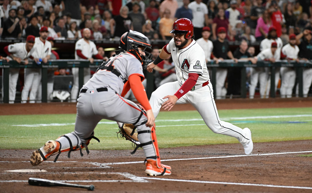 PHOENIX, ARIZONA - SEPTEMBER 25: Eugenio Suarez #28 of the Arizona Diamondbacks scores on a sacrifi...