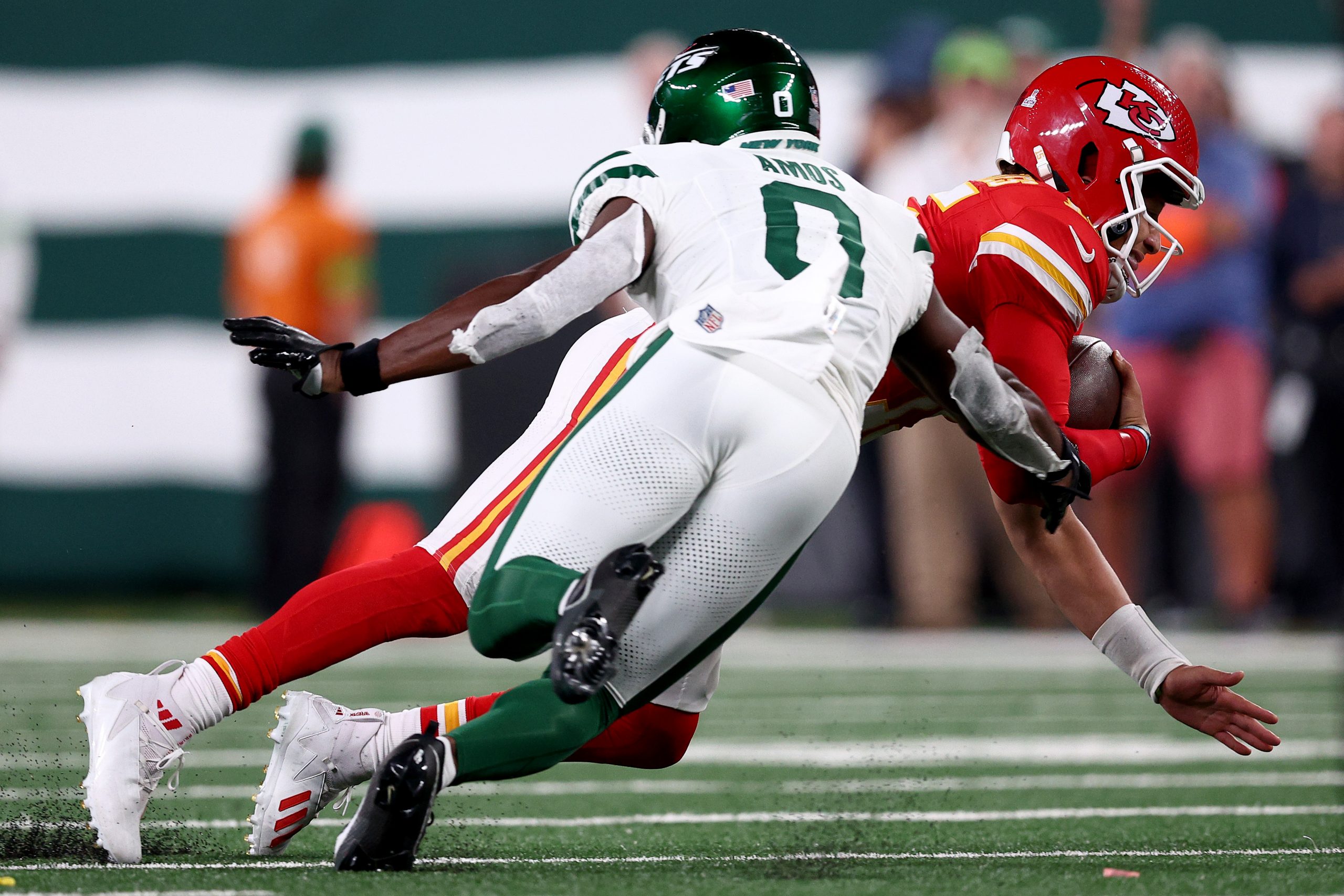 Patrick Mahomes #15 of the Kansas City Chiefs is tackled by Adrian Amos #0 of the New York Jets dur...