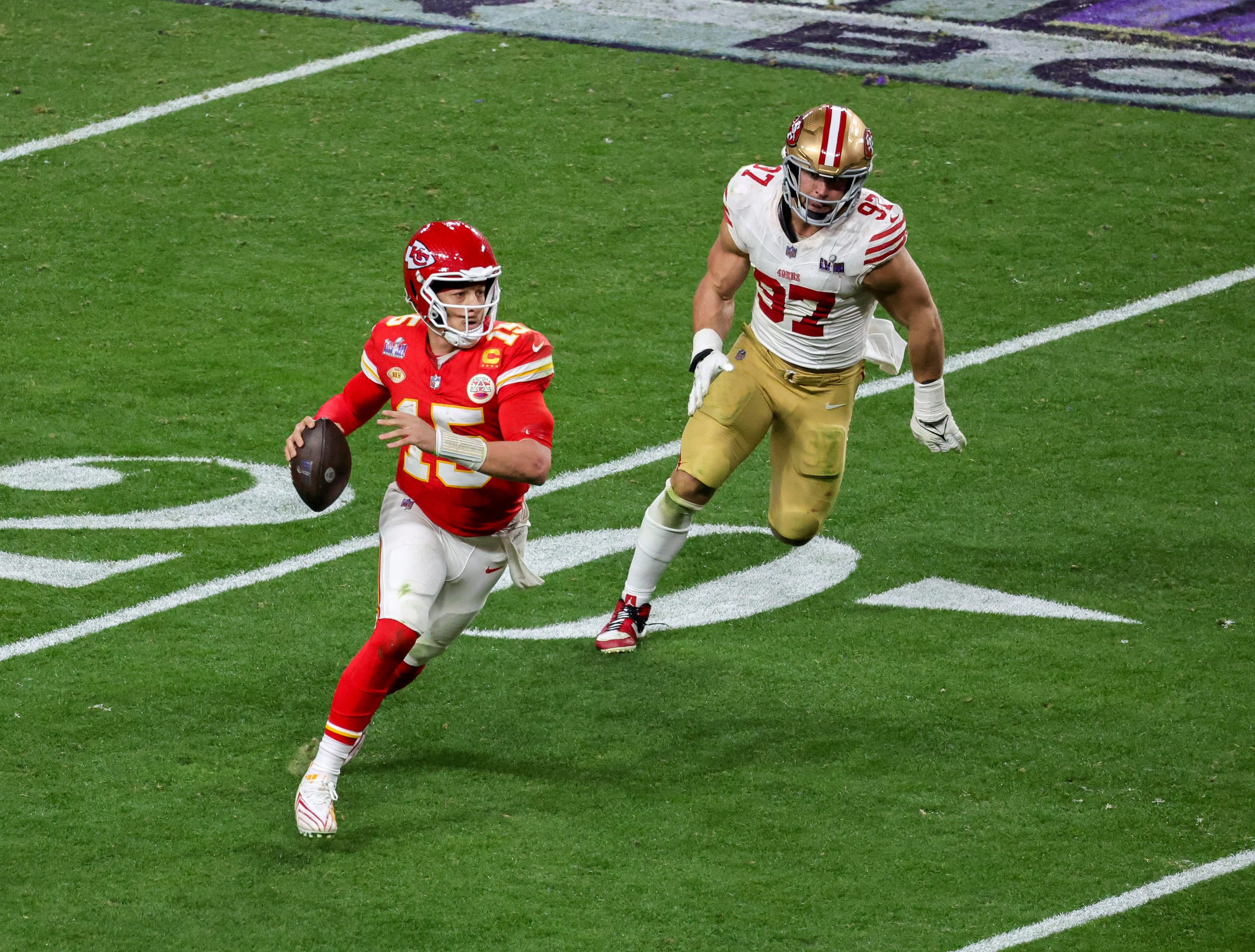 Quarterback Patrick Mahomes #15 of the Kansas City Chiefs looks to throw under pressure from defens...