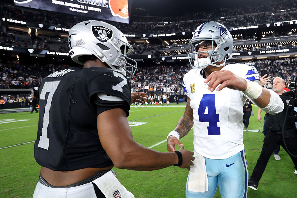 LAS VEGAS, NEVADA - NOVEMBER 17: (L-R) Geno Smith #7 of the Las Vegas Raiders embraces Dak Prescott...
