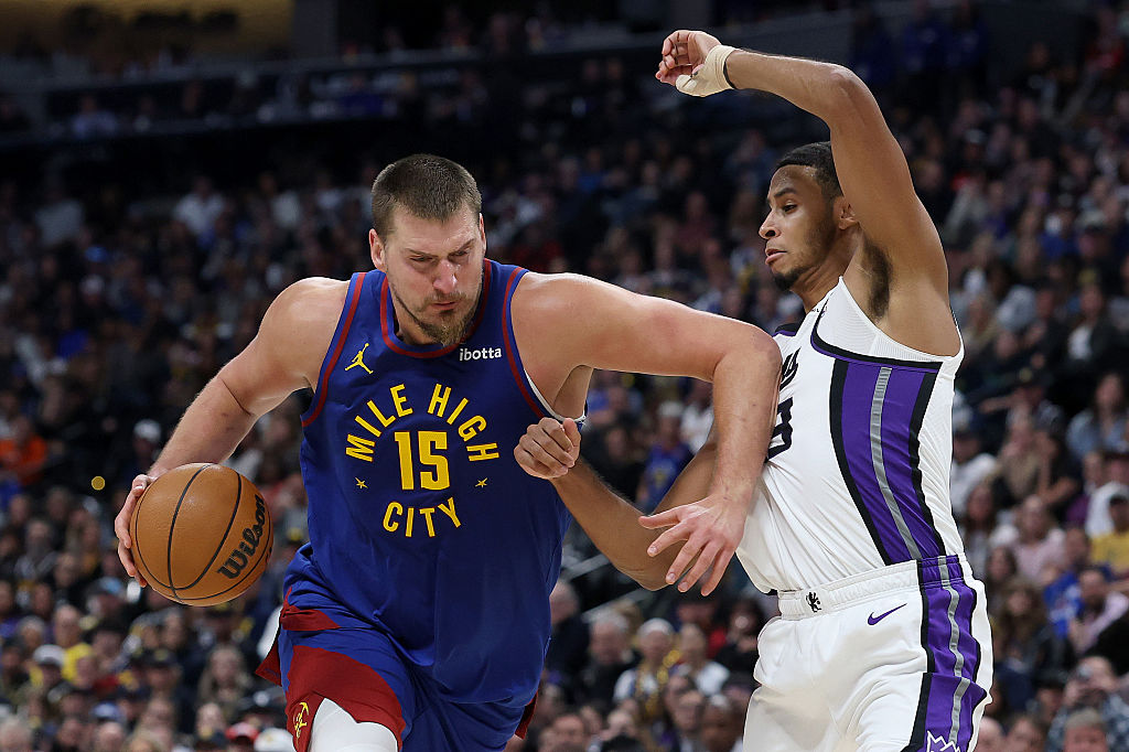 DENVER, COLORADO - NOVEMBER 22: Nikola Jokic #15 of the Denver Nuggets drives against Keegan Murray...