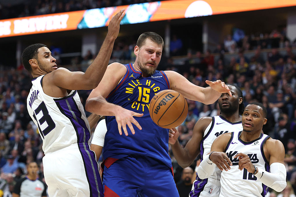 DENVER, COLORADO - NOVEMBER 22: Nikola Jokic #15 of the Denver Nuggets loses the ball against Keega...