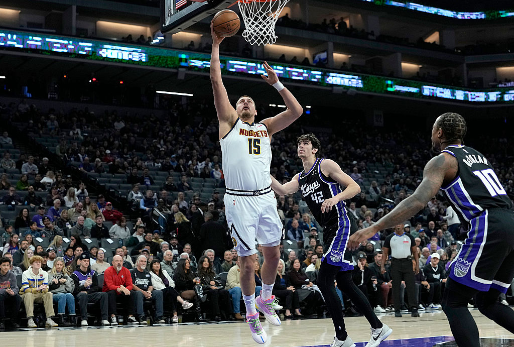 SACRAMENTO, CALIFORNIA - DECEMBER 11: Nikola Jokic #15 of the Denver Nuggets shoots over Maxime Ray...