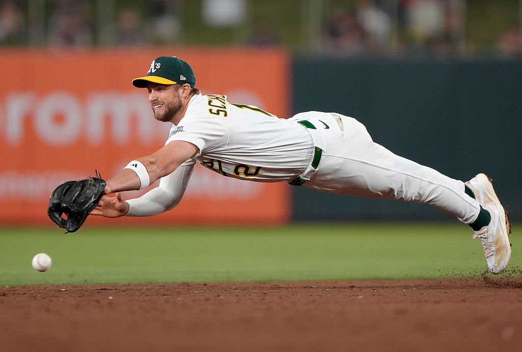 SACRAMENTO, CALIFORNIA - JUNE 02: Max Schuemann #12 of the Athletics dives for a ball that gets pas...
