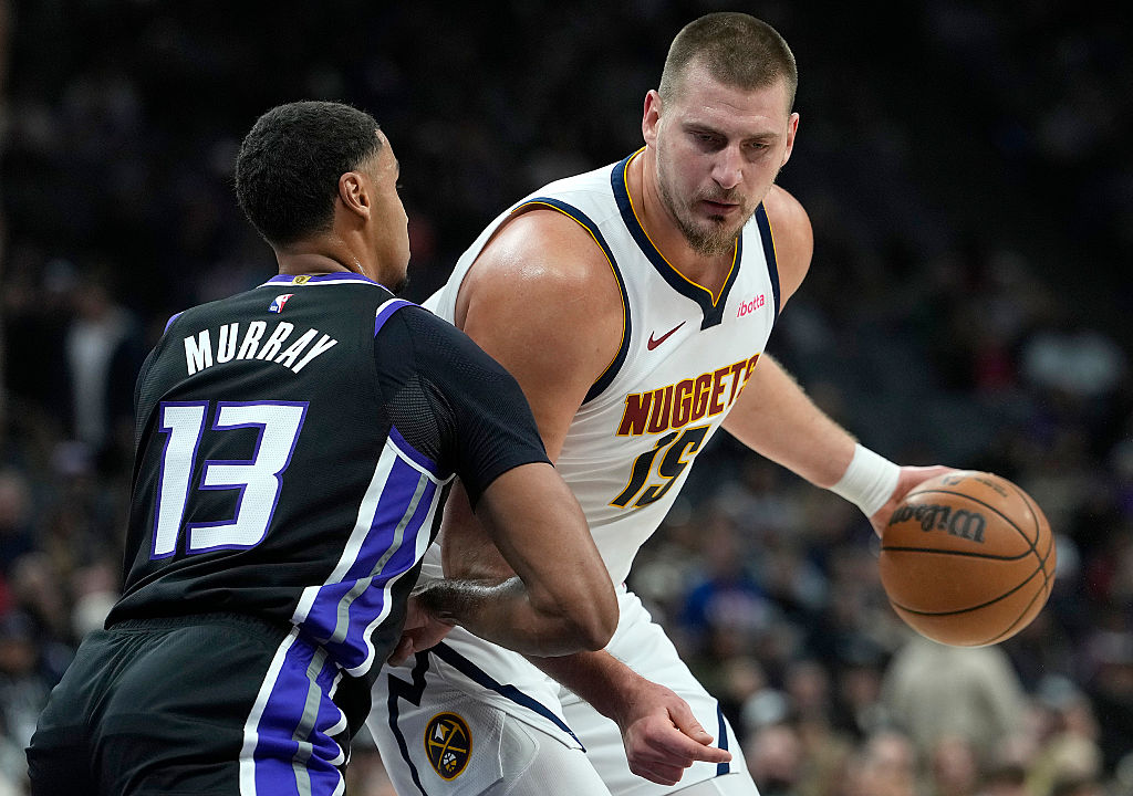 SACRAMENTO, CALIFORNIA - DECEMBER 11: Nikola Jokic #15 of the Denver Nuggets backs in on Keegan Mur...