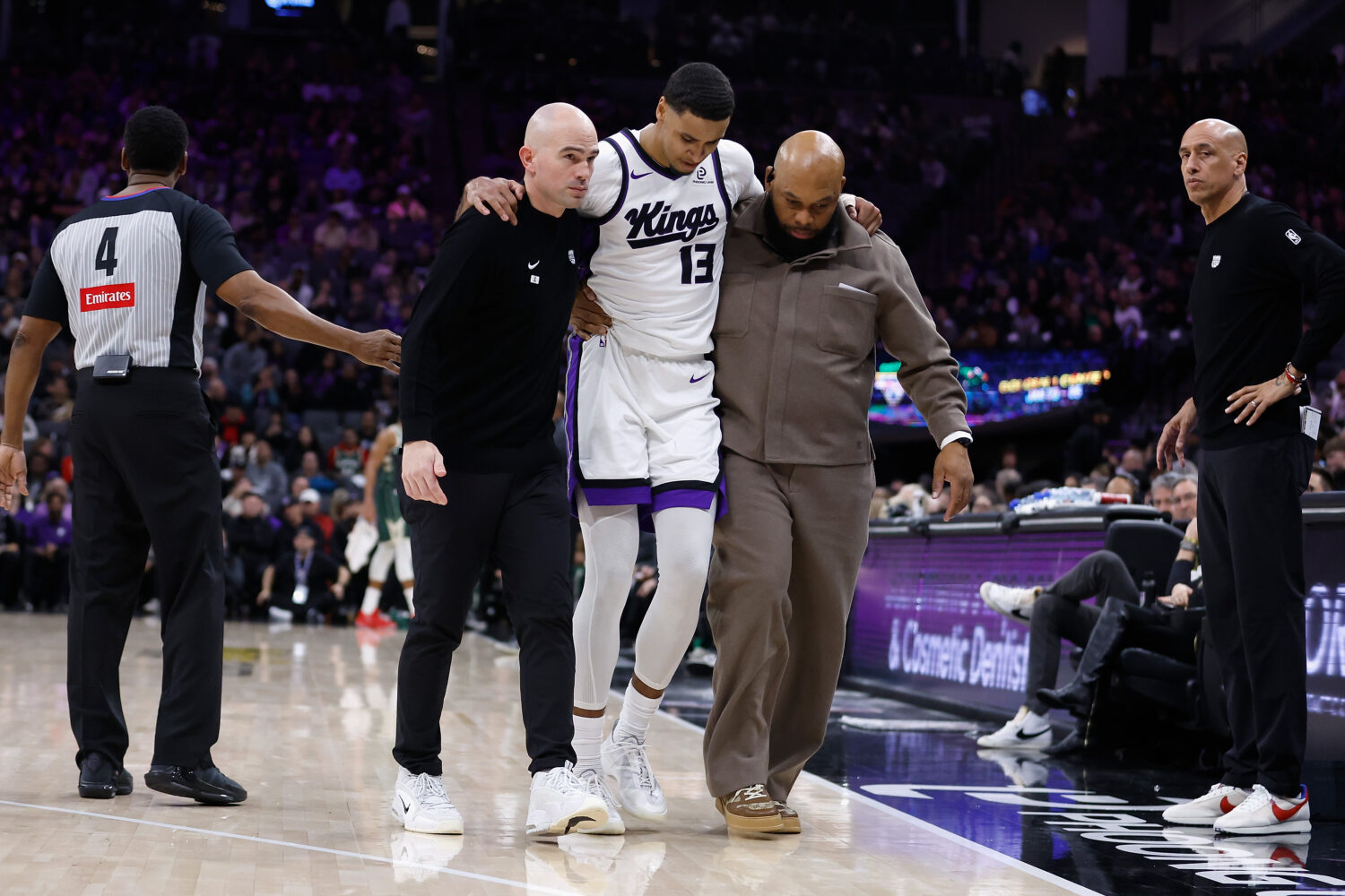 SACRAMENTO, CALIFORNIA - JANUARY 04: Keegan Murray #13 of the Sacramento Kings is assisted from the...