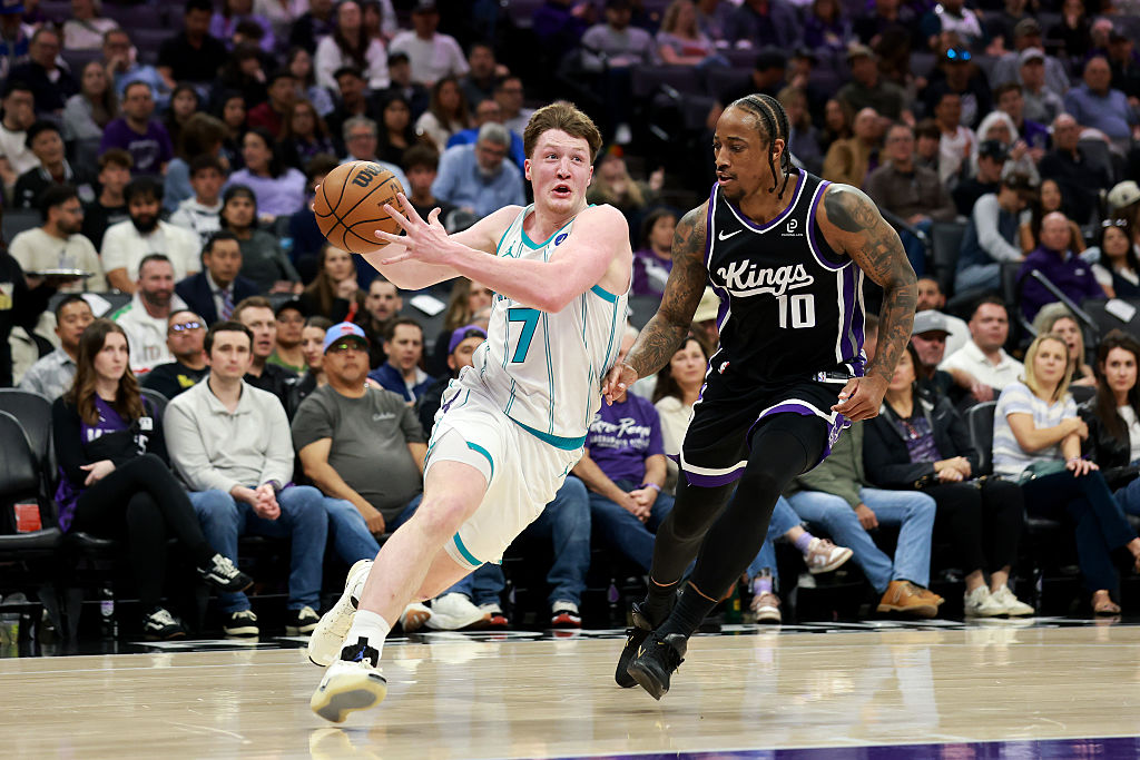 SACRAMENTO, CALIFORNIA - MARCH 11: Kon Knueppel #7 of the Charlotte Hornets is guarded by DeMar DeR...