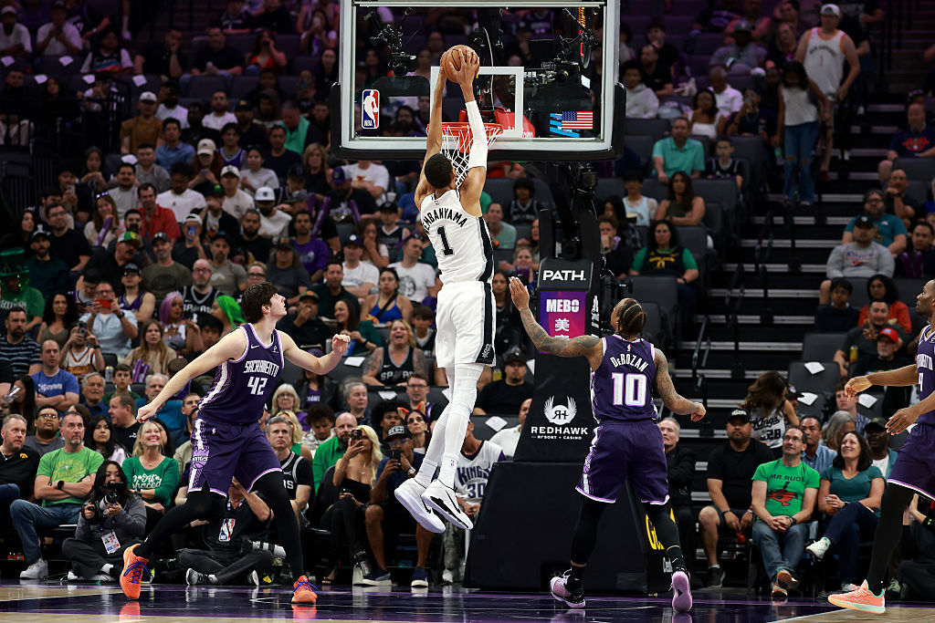 SACRAMENTO, CALIFORNIA - MARCH 17: Victor Wembanyama #1 of the San Antonio Spurs dunks on Maxime Ra...