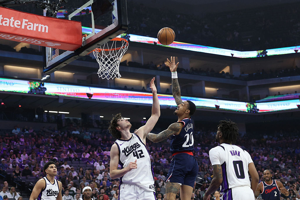 SACRAMENTO, CALIFORNIA - APRIL 05: John Collins #20 of the Los Angeles Clippers scores over Maxime ...