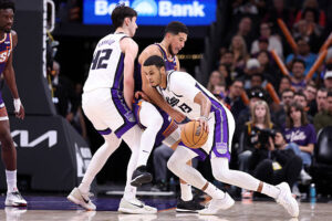 PHOENIX, ARIZONA - JANUARY 02: Keegan Murray #13 dribbles around a screen set by Maxime Raynaud #42 of the Sacramento Kings on Devin Booker #1 of the Phoenix Suns during the second half at Mortgage Matchup Center on January 02, 2026 in Phoenix, Arizona. The Suns defeated the Kings 129-102. NOTE TO USER: User expressly acknowledges and agrees that, by downloading and or using this photograph, User is consenting to the terms and conditions of the Getty Images License Agreement. (Photo by Chris Coduto/Getty Images)