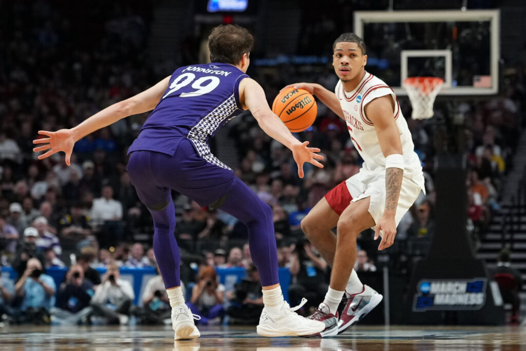 PORTLAND, OREGON - MARCH 21: Darius Acuff Jr. #5 of the Arkansas Razorbacks dribbles the ball while being guarded by Chase Johnston #99 of the High Point Panthers during the second half in the second round of the 2026 NCAA Men's Basketball Tournament at Moda Center on March 21, 2026 in Portland, Oregon.  (Photo by Soobum Im/Getty Images)