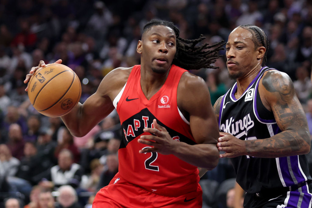 SACRAMENTO, CALIFORNIA - NOVEMBER 06: Jonathan Mogbo #2 of the Toronto Raptors is guarded by DeMar ...
