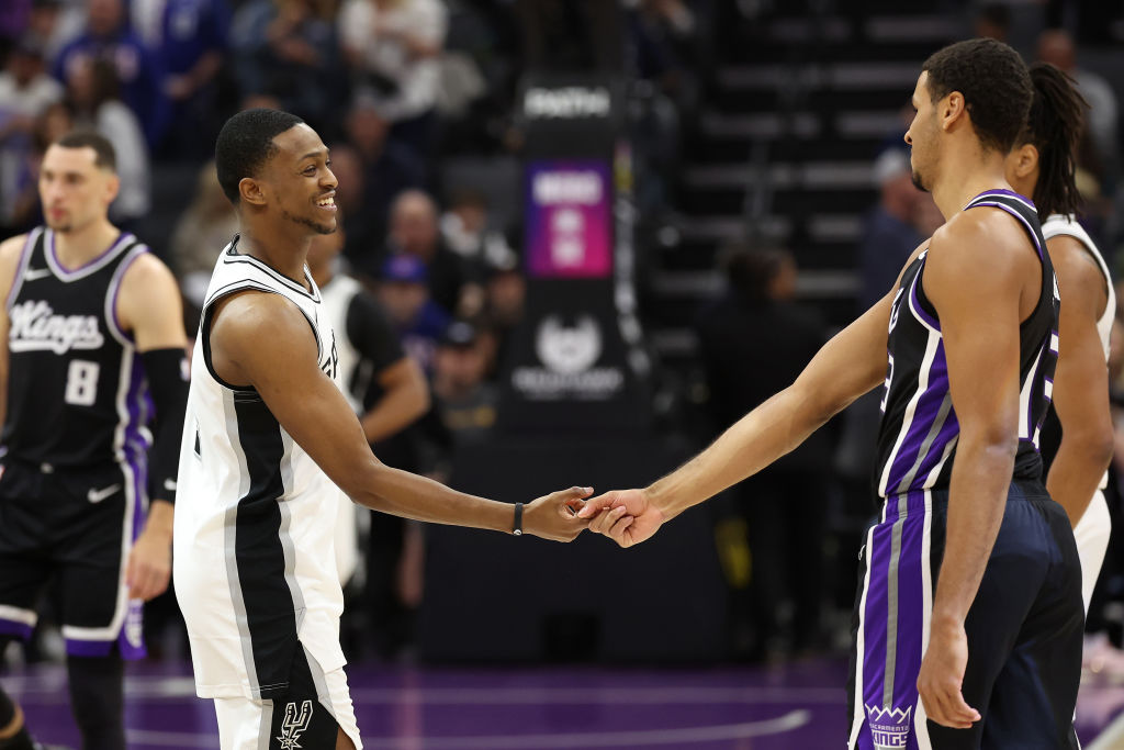 SACRAMENTO, CALIFORNIA - MARCH 07: De'Aaron Fox #4 of the San Antonio Spurs shakes hands with Keega...