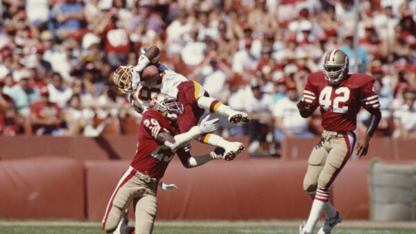Ricky Sanders #83, Wide Receiver for the Washington Redskins jumps to make a running catch against Don Griffin #29 and #42 Ronnie Lott of the San Francisco 49ers during the National Football Conference West game against the San Francisco 49ers on 16 September 1990 at Candlestick Park, San Francisco, California, United States. The 49ers won the game 26 - 13. (Photo by Otto Greule JrAllsport/Getty Images)