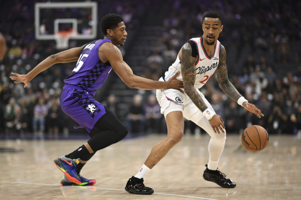 SACRAMENTO, CALIFORNIA - FEBRUARY 06: John Collins #20 of the Los Angeles Clippers dribbles against De'Andre Hunter #15 of the Sacramento Kings in the first quarter at Golden 1 Center on February 06, 2026 in Sacramento, California. NOTE TO USER: User expressly acknowledges and agrees that, by downloading and or using this photograph, User is consenting to the terms and conditions of the Getty Images License Agreement. (Photo by Eakin Howard/Getty Images)