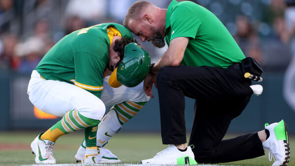 SACRAMENTO, CALIFORNIA - AUGUST 14: Jacob Wilson #5 of the Athletics is checked on by a trainer after being hit by a pitch during the bottom of the first inning against the Texas Rangers at Sutter Health Park on August 14, 2026 in Sacramento, California. (Photo by Scott Marshall/Getty Images)