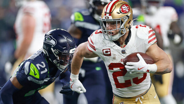 SEATTLE, WASHINGTON - JANUARY 17: Christian McCaffrey #23 of the San Francisco 49ers runs the ball against Devon Witherspoon #21 of the Seattle Seahawks during the second quarter in the NFC Divisional Playoff game at Lumen Field on January 17, 2026 in Seattle, Washington. (Photo by Harry How/Getty Images)