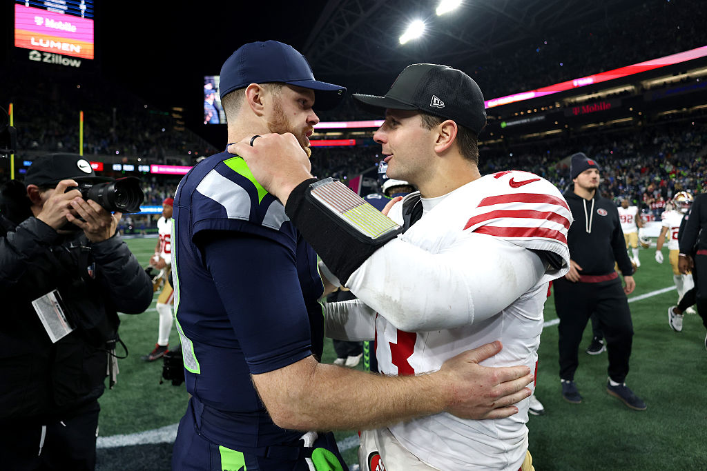 SEATTLE, WASHINGTON - JANUARY 17: Brock Purdy #13 of the San Francisco 49ers and Sam Darnold #14 of the Seattle Seahawks embrace after the game in the NFC Divisional Playoff game at Lumen Field on January 17, 2026 in Seattle, Washington. (Photo by Harry How/Getty Images)